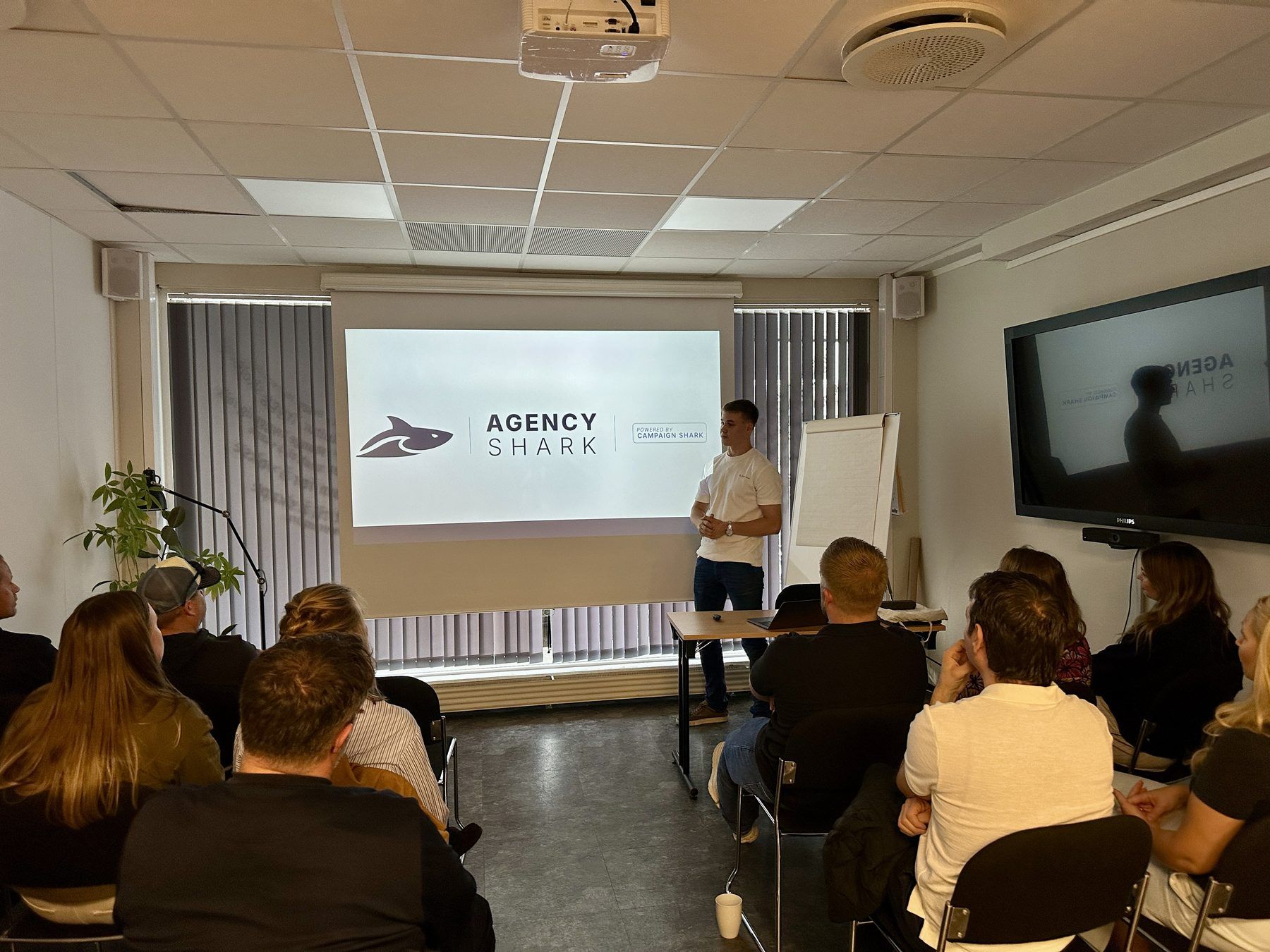 Adrian Siggerud holder foredrag for et fullsatt rom med lokale bedrifter